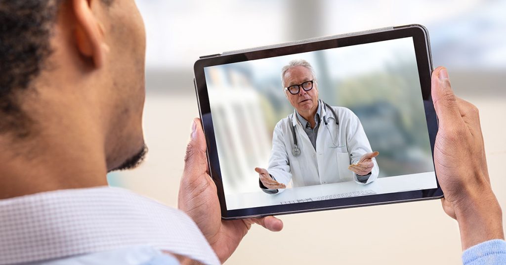 Telemedicine and health care concept with a young man and a doctor on computer screen; blog: 5 Benefits of Telehealth For Patients & Providers