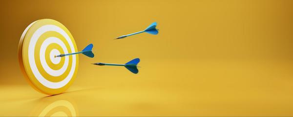A yellow target with blue darts to represent Goals for Your Medical Practice